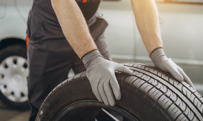 Close-up Car Mechanic holding a tire at the repair garage.